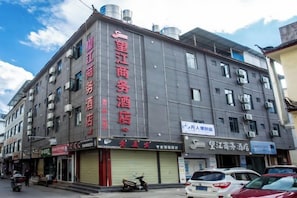 Un immeuble à plusieurs étages, dont le rez-de-chaussée est occupé par des commerces et affiche des enseignes publicitaires, et qui comprend un hôtel et un centre de services aux entreprises.