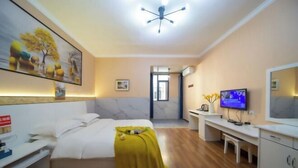 A bedroom with a bed, bedside table, TV, and a view of the hallway. - Nanyou Hotel Lijiang Wangjiang Business Hotel (Lijiang)