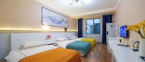 A hotel room with three beds, a desk, a television, and a window with curtains.