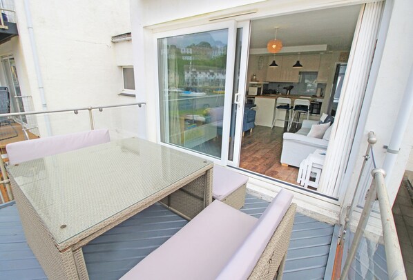 A balcony with a glass door leading to a kitchen area. - Dros Y Dwr (Porthmadog)