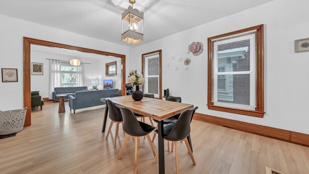 A spacious room with a wooden dining table, black chairs, and a modern chandelier. - 7bdrm, 3baths, 2 kitchens, mins to falls, Arcade, WiFi, AC, parking (Niagara Falls)