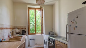 A compact kitchen with a washing machine, a toaster, and a refrigerator. - Farmhouse in Giroux Near Forest & Lake (Giroux)