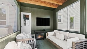 A cozy room with a fireplace, a sofa, and a TV. - Chestnut Estate: 2 Homes · Hot Tub + Fire Pit (Douglas)
