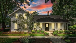 A single-story house with a front porch, a chimney, and a well-maintained garden. - Chestnut Estate: 2 Homes · Hot Tub + Fire Pit (Douglas)