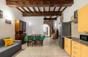Cozy living space with a kitchen area, dining table, and sofa.