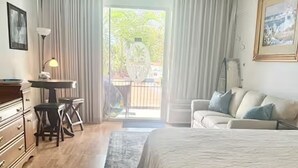 Um quarto com cama, escrivaninha, cadeira e sofá.
