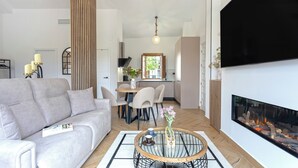 A modern living room with a sofa, a round coffee table, and a fireplace. - Mirador de Aixa (Granada)
