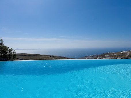 Una piscina al aire libre de temporada, sillones reclinables de piscina