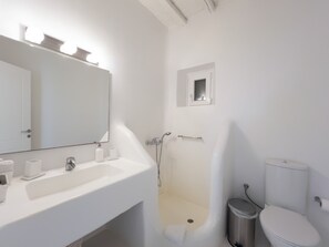 Une salle de bain moderne avec un lavabo blanc, un miroir et une baignoire.