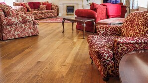 A spacious living room with patterned sofas and a wooden floor. - 6 bedroom accommodation in Narbeth (Narbeth)