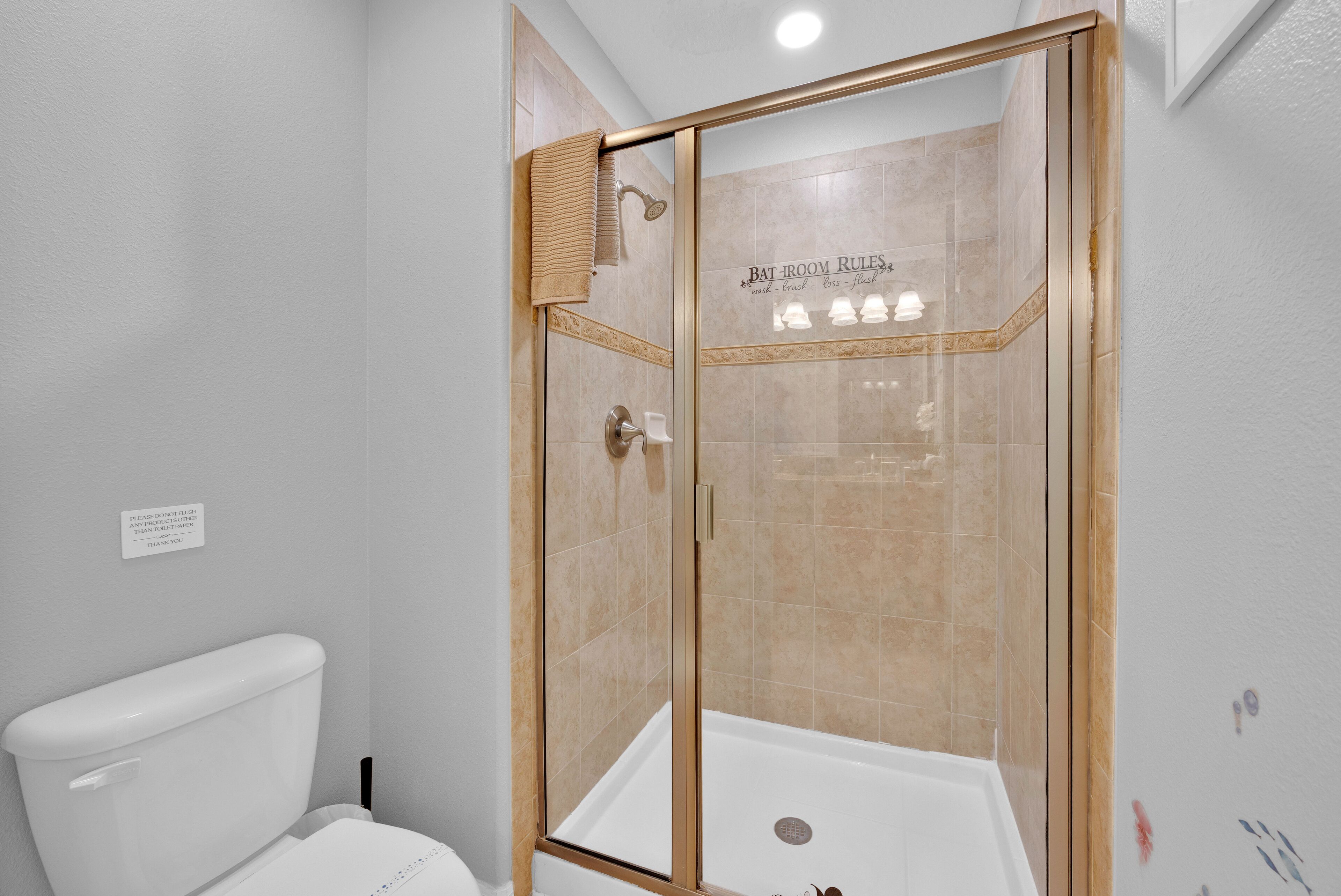 A modern bathroom with a glass-enclosed shower, a toilet, and a bathtub.