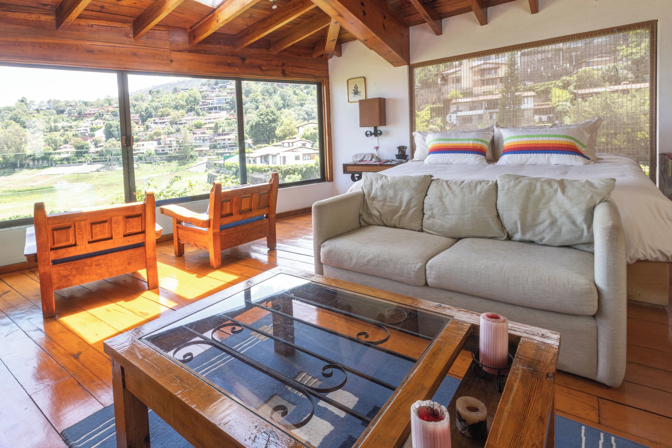 Une pièce confortable avec un grand lit, une table basse en bois et une vue sur une colline.