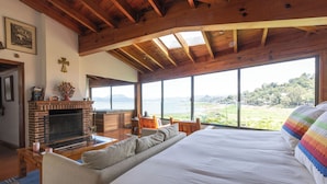 Une chambre spacieuse avec un grand lit, une cheminée et une vue sur le paysage.