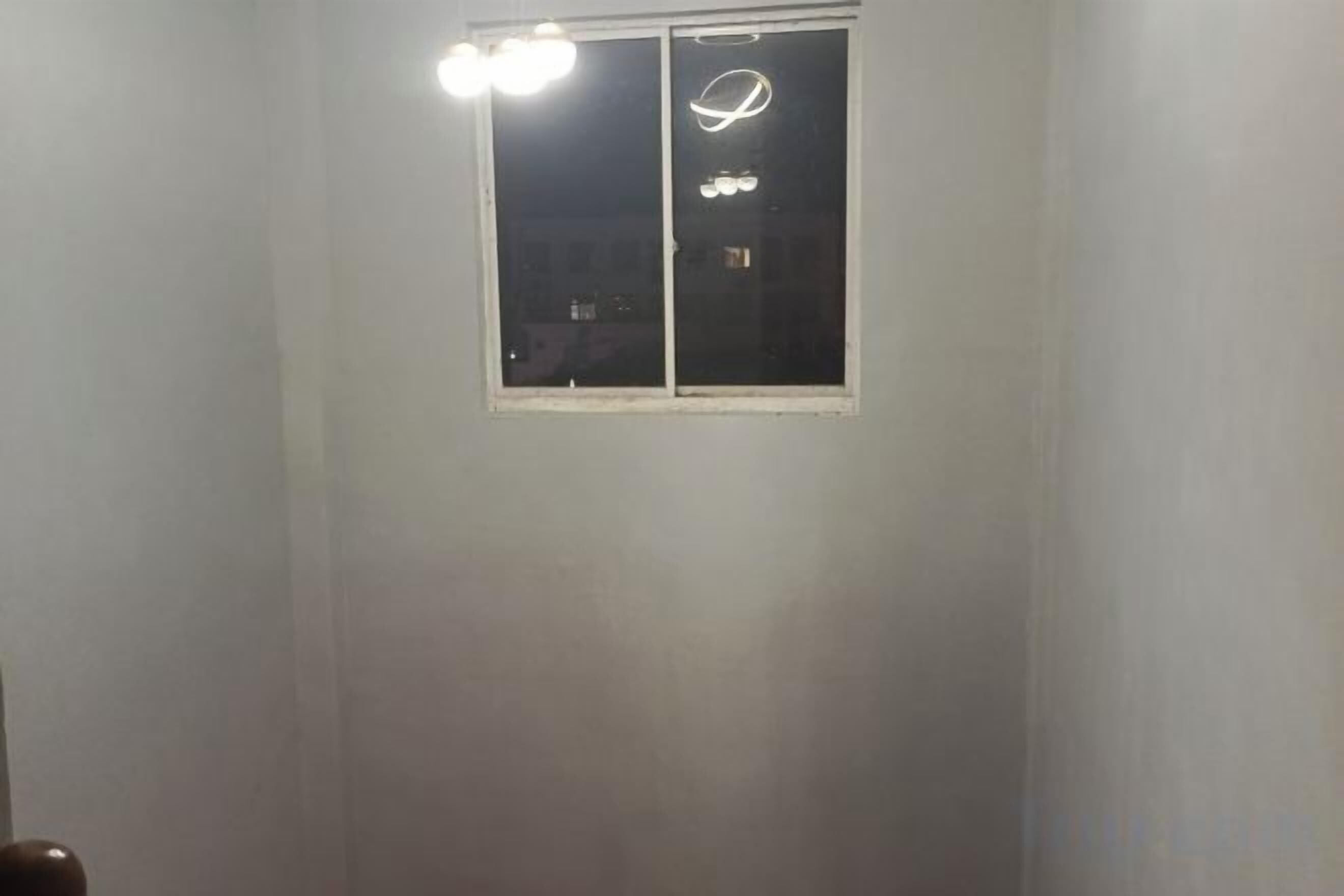 A room with a window, a door, and a light fixture.