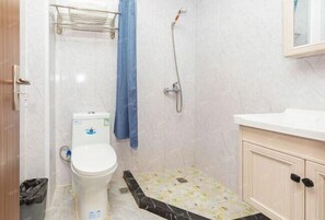 Un baño con inodoro, ducha y lavamanos.