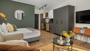 A modern apartment with a bed, a dining area, a kitchen, and a living room.