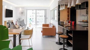 Een modern appartement met een eetgedeelte, een zithoek en een keuken.