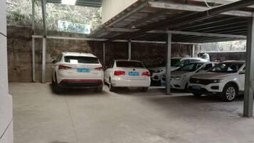 Ein überdachter Parkbereich mit drei geparkten Autos.