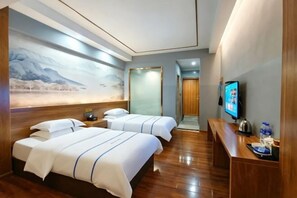 A hotel room with two beds, a television, a desk, and a painting on the wall. - Mojiang XinXing Business Hotel (Mojiang)