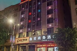 A building with multiple floors, illuminated by external lights. - Mojiang XinXing Business Hotel (Mojiang)