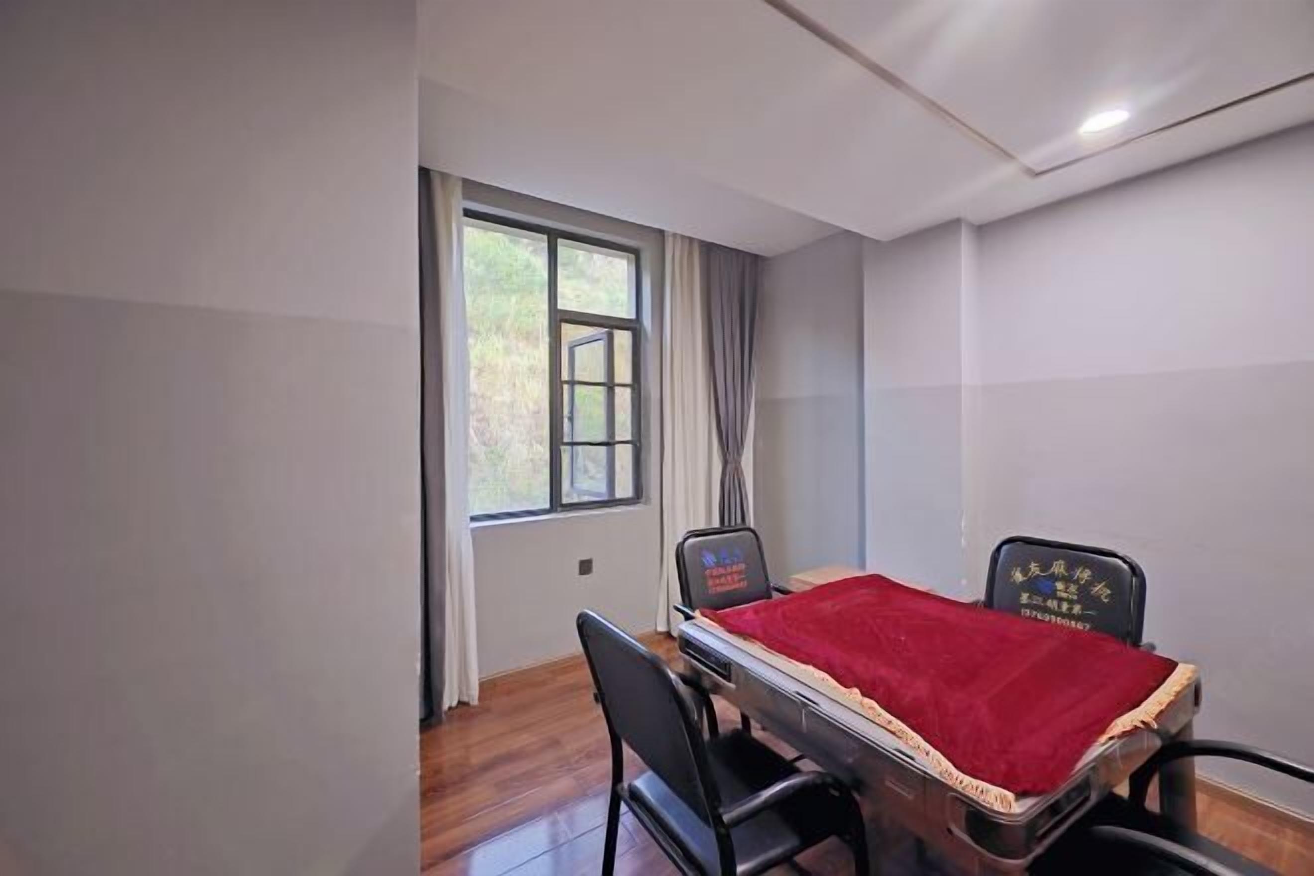 Una habitación con cama, escritorio y silla. Hay una ventana con cortinas y las paredes están pintadas de blanco.