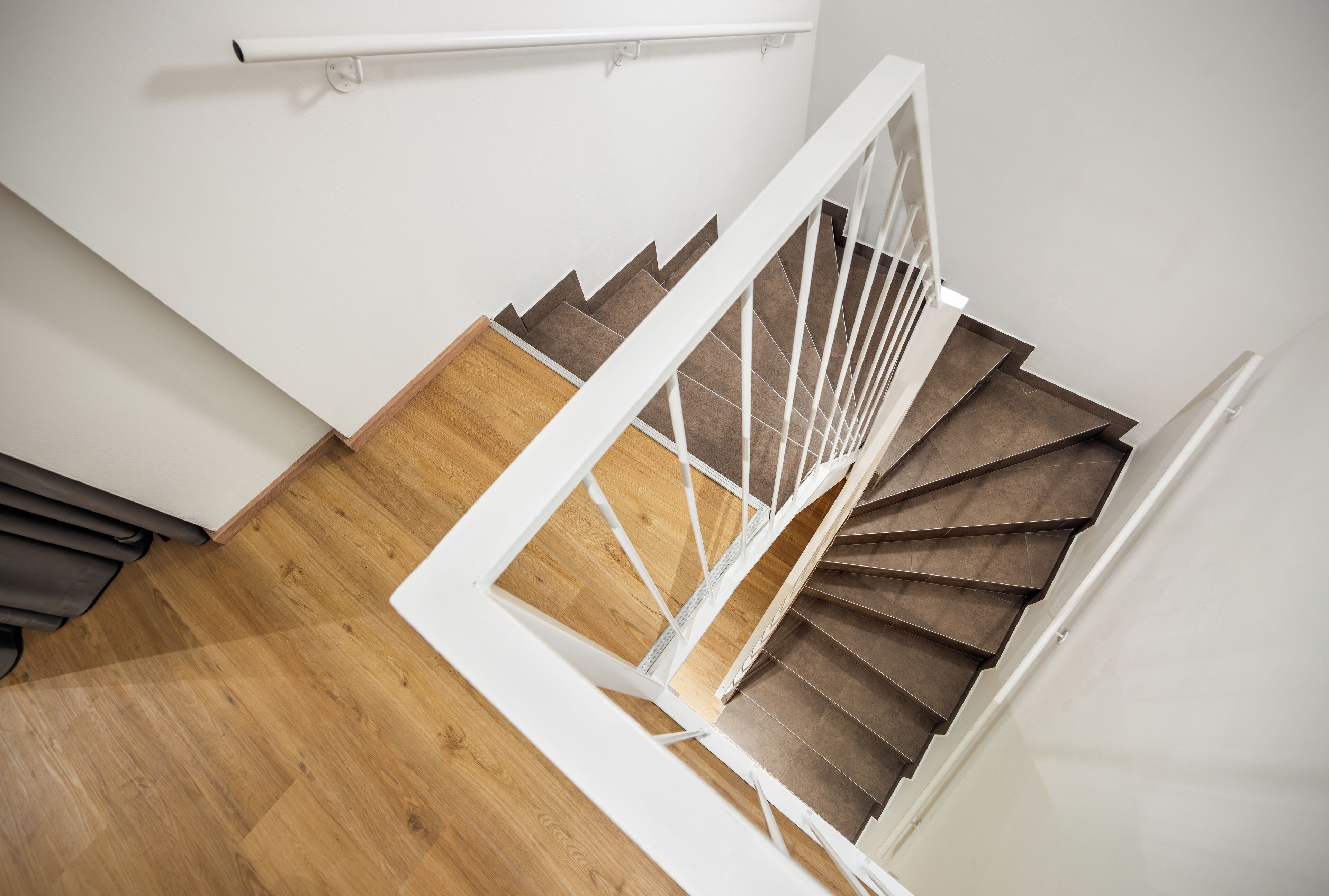 Een moderne trap met houten treden en witte leuningen.
