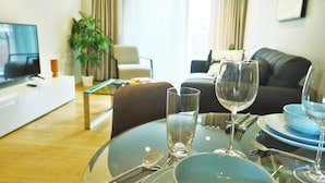 A dining area with a glass table set for two, including wine glasses, plates, and cutlery. - Accomodo London Southbank - Spacious & Elegant Apartments near Big Ben & London Eye (London)