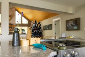 A kitchen counter with a knife block, a vase with flowers, and a toaster.
