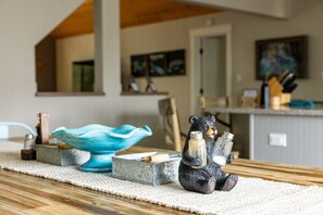 Un plan de travail de cuisine avec un salière en forme d’ours, un bol en céramique bleue et un récipient en métal.