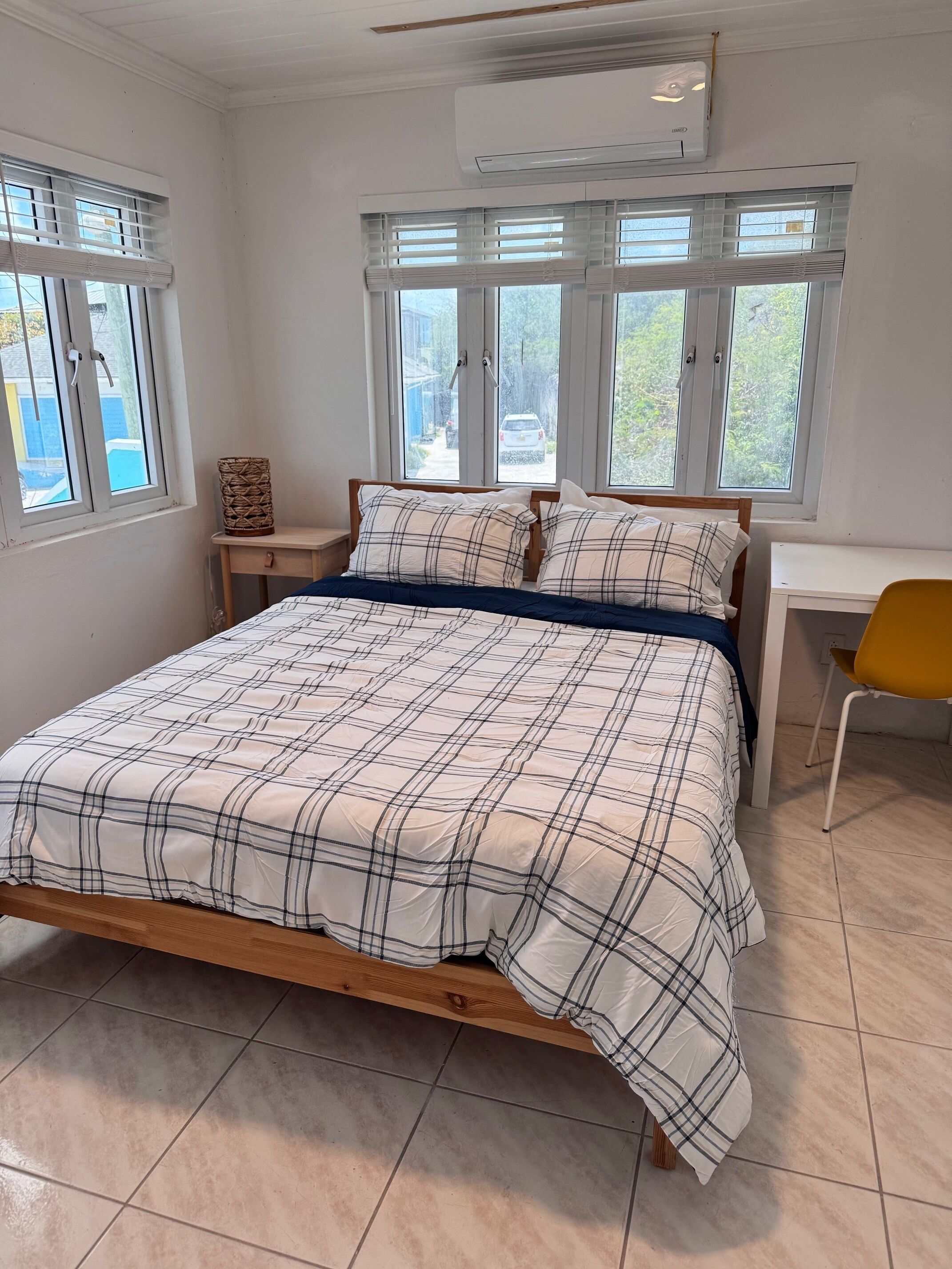 A bedroom with a bed, a desk, and a chair.