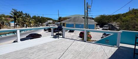 Une terrasse sur le toit avec une piscine, des palmiers et une vue sur les environs.