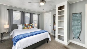 A bedroom with a bed, a ceiling fan, a wardrobe, and a window with curtains. - Clean, quiet 2BR home with utilities included and fast WiFi. Comfortable setup with open surroundings and easy access to downtown Kansas City (about 15 minutes). Ideal for short stays, work trips, or a simple, reliable place to unwind. (Sugar Creek)