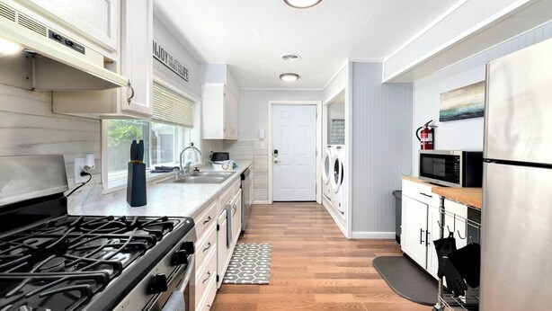 A modern kitchen with a gas stove, stainless steel appliances, and a built-in oven.