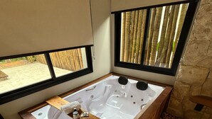 Ein modernes Badezimmer mit einer großen Badewanne, Holzelementen und Blick ins Freie.