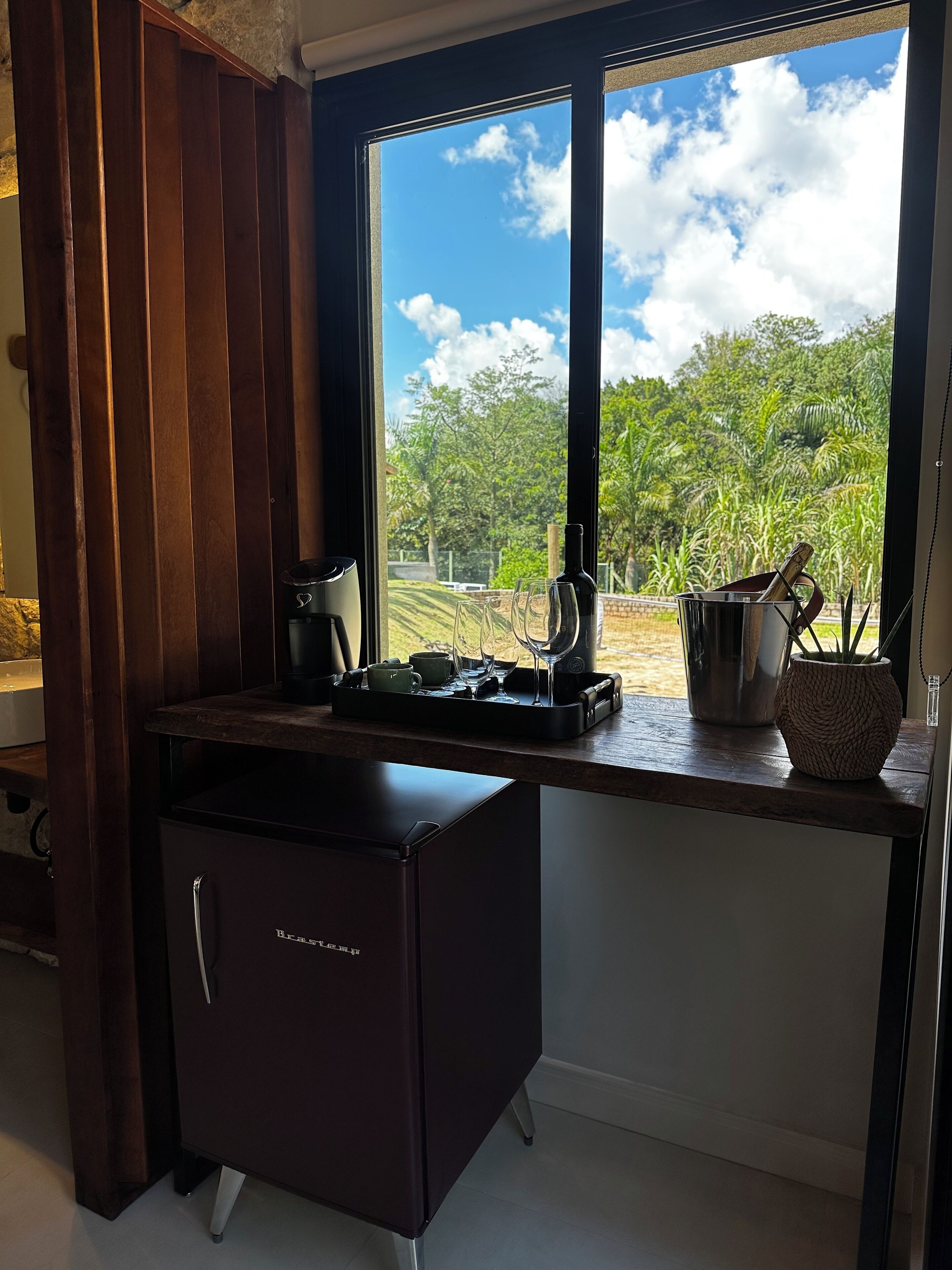 Cozinha com vista para um jardim através de uma grande janela.