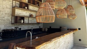Eine moderne Küche mit freiliegenden Backsteinwänden, Holzbalken und einer Stein Arbeitsplatte.