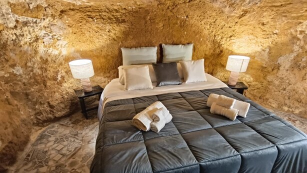 A room with a bed, pillows, and two bedside tables with lamps. - Historic Apartment (Agrigento)