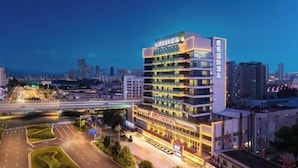 Een hotel met meerdere verdiepingen, met een modern ontwerp, een opvallende entree en een goed verlichte gevel.