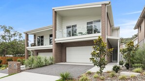 A modern two-story house with a garage, a balcony, and a well-maintained garden. - Stillwater on Stockton, 57B Stockton St - complete luxury in the heart of town (Nelson Bay)