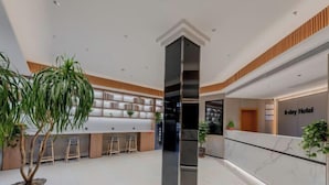 A modern hotel lobby with a reception desk, bar area, and seating. - 8 Days Hotel (Minhang Jiaotong University Branch) (Shanghai)