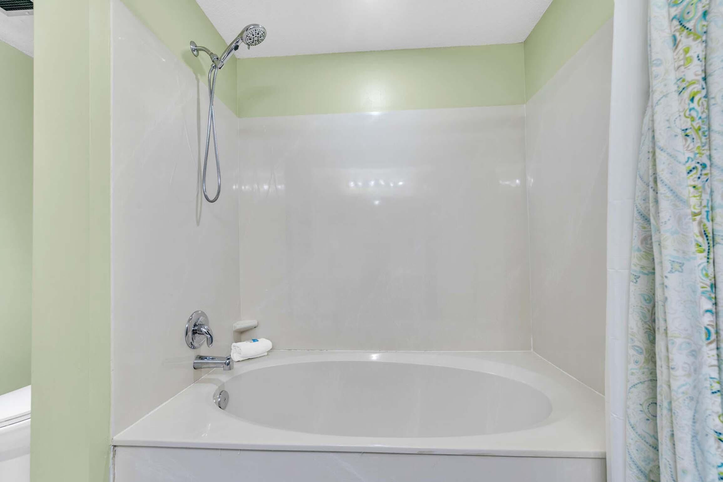 A bathroom with a bathtub, a shower, and a toilet.
