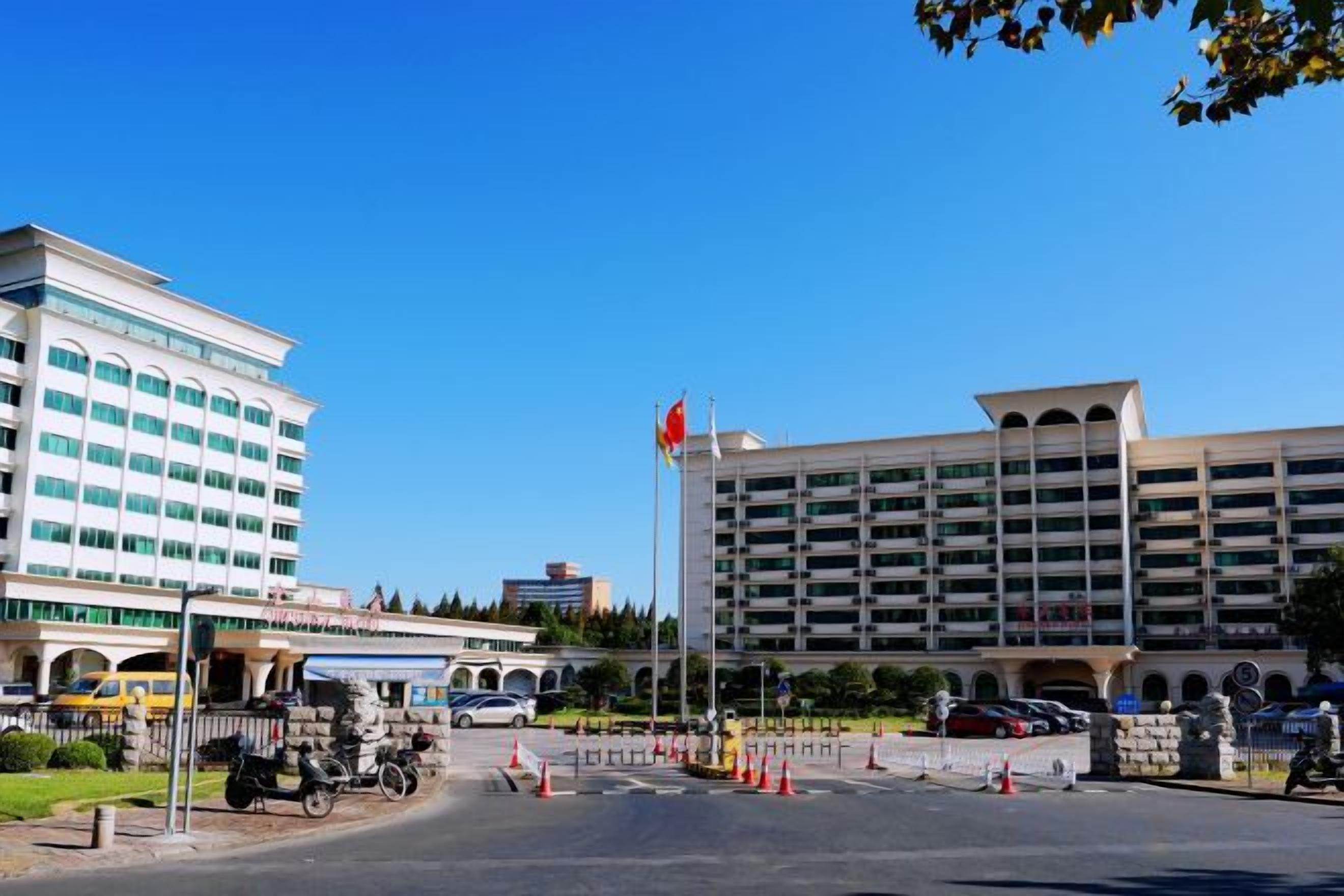 Un edificio de varios pisos con una zona de estacionamiento al frente.