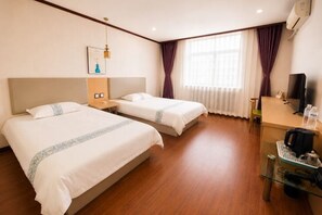 Een hotelkamer met twee bedden, een bureau, een stoel, een televisie en een raam met gordijnen.