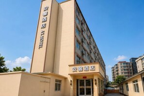 A hotel building with a vertical sign and a horizontal sign at the entrance. - Anxin Express Hotel (Shijiazhuang New Railway Station East Plaza) (Shijiazhuang)