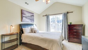 A bedroom with a large bed, a nightstand with a lamp, a dresser, and a ceiling fan. - Spacious Retreat Near RDU ~ Pool, BBQ, Fast Wi-Fi & Easy Self Check-In (Morrisville)