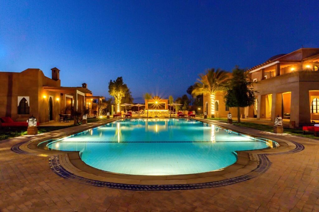 Una piscina al aire libre, sombrillas, sillones reclinables de piscina