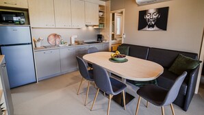 Een moderne keuken met een eethoek, inclusief een tafel en stoelen, en een inbouwoven.