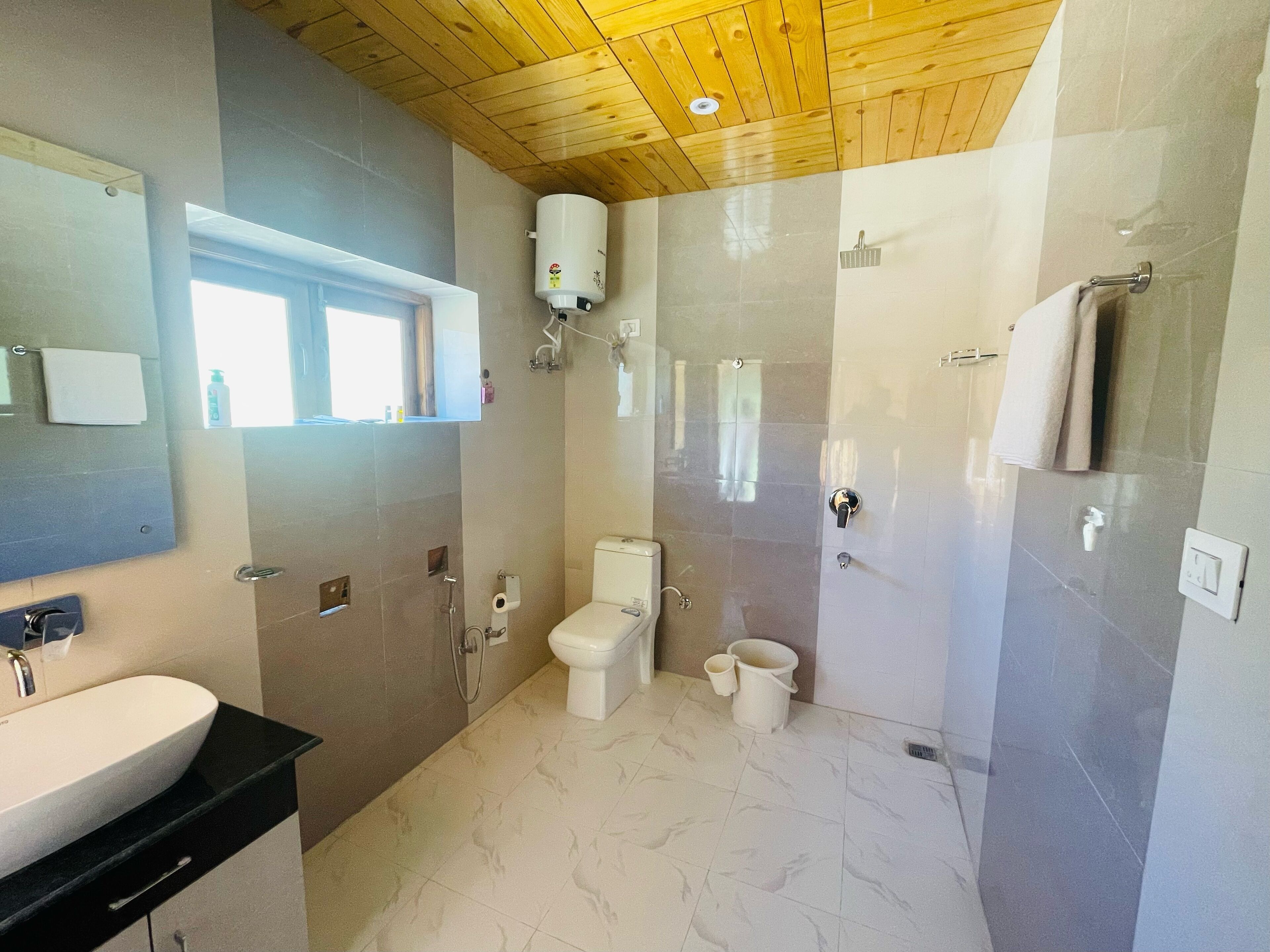 A modern bathroom with a large sink, toilet, and shower area.