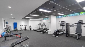 A gym with treadmills, elliptical machines, and weightlifting equipment. - Sky-High 2BR|Spectacular Views|Free Parking! (South Brisbane)