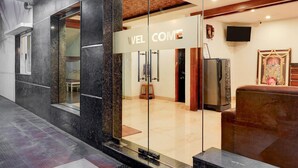 A modern hotel lobby with a 'WELCOME' sign, a television, and a decorative shrine. - Super Townhouse Arcot Road (Chennai)